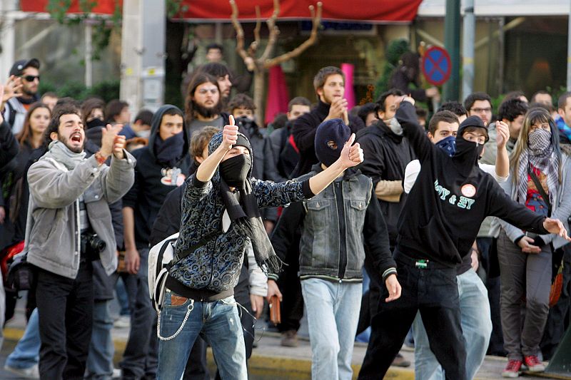 Un grupo de estudiantes grita consignas durante los enfrentamientos frente a la principal comisaría de Atenas.