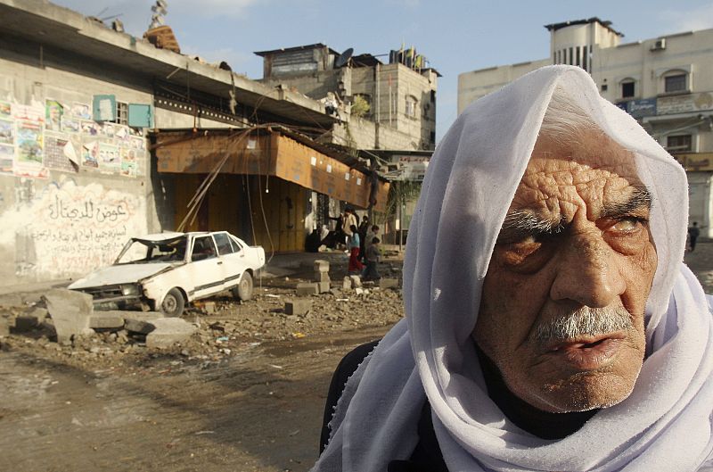 Un hombre palestino pasa por delante de un coche destrozado en Jabalya, en Gaza.