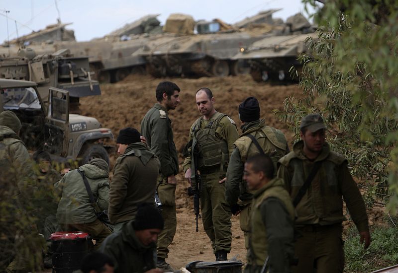 Soldados israelíes esperan junto a vehículos pesados junto a la Franja de Gaza.