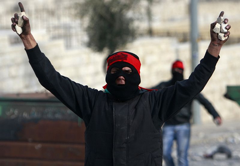 Manifestante palestino con piedras para tirarlas durante una protesta en Jerusalem contra los bombardeos israelíes sobre Gaza.