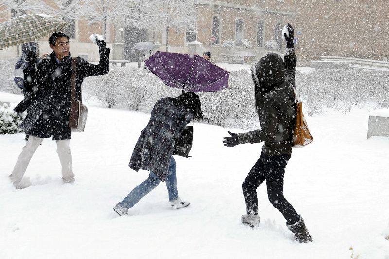 Varios jóvenes se lanzan bolas de nieve en Alcalá de Henares