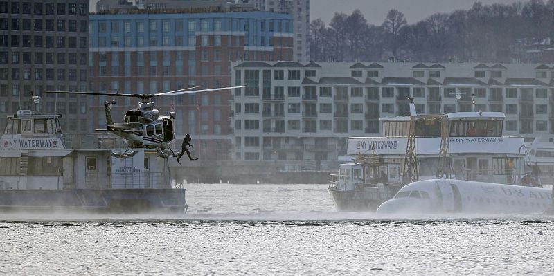 A diver jumps into the water next to a U.S. Airways plane that crashed into the Hudson River in New York