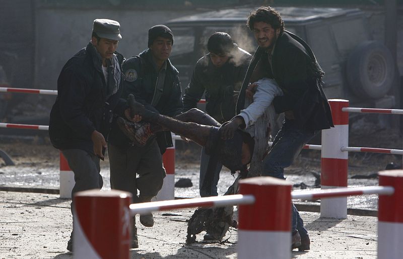 People carry a victim of a blast at the German embassy in Kabul