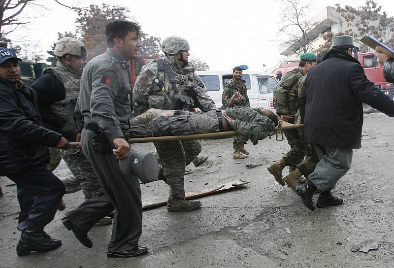 People carry a wounded U.S. soldier after a blast outside the German embassy in Kabul