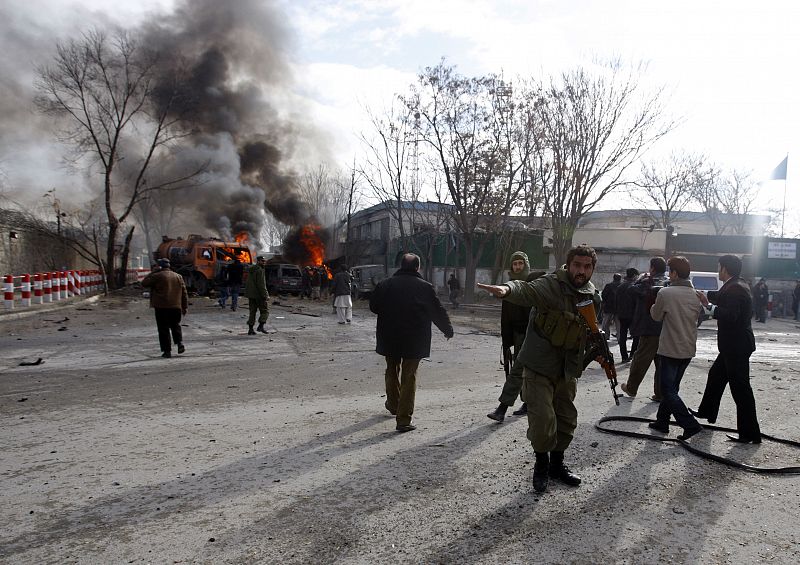 Afghan policeman reacts in front of a blast site outside the German embassy in Kabul