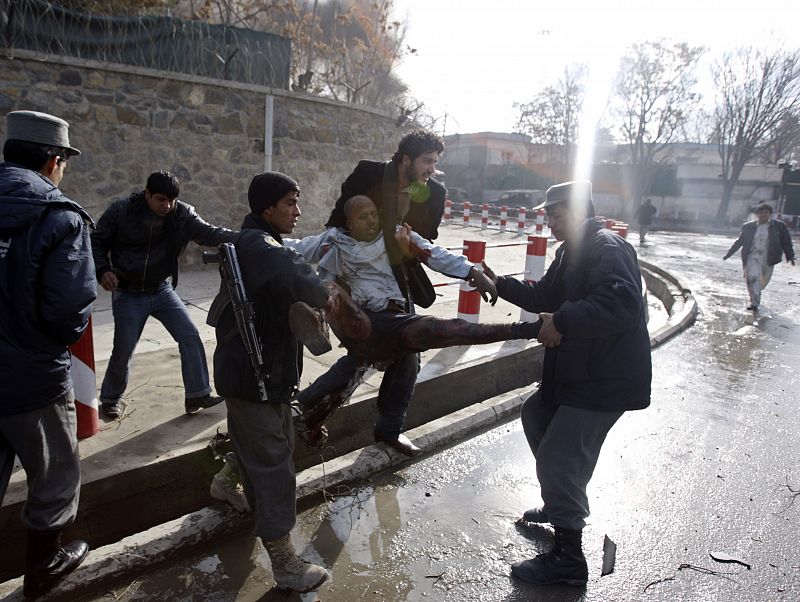 People carry a victim of a blast at the German embassy in Kabul