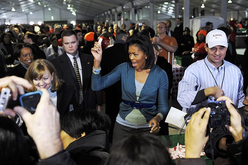 Michelle Obama holds up toiletries as she helps volunteers assemble care packages for US troops overseas in Washington