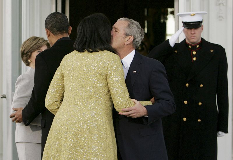 U.S. President George W. Bush kisses Michelle Obama in front of the White House in Washington