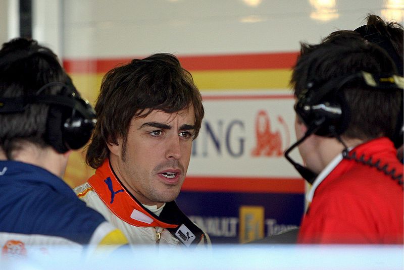 Fernando Alonso intercambia impresiones con sus técnicos en el box de Renault.