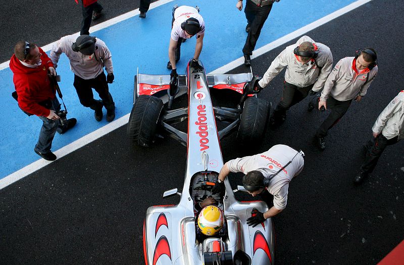 Los mecánicos de McLaren cuidan el coche de Hamilton antes de salir al circuito