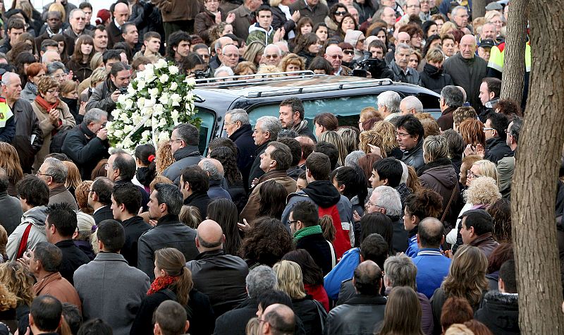 Cientos de personas acompañan la llegada del coche fúnebre de uno de los cuatro niños.