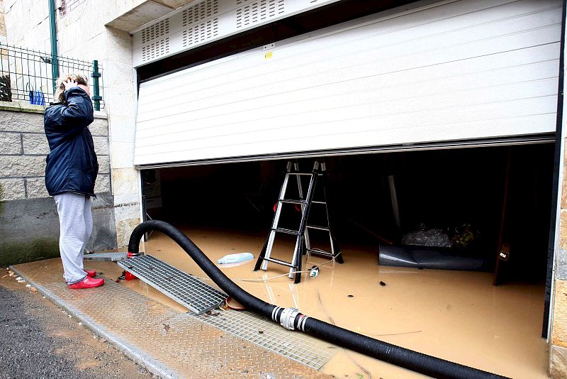 Una vecina de Sámano, en Cantabria, observa su garaje inundado después de que el río Brazomar se desbordara.