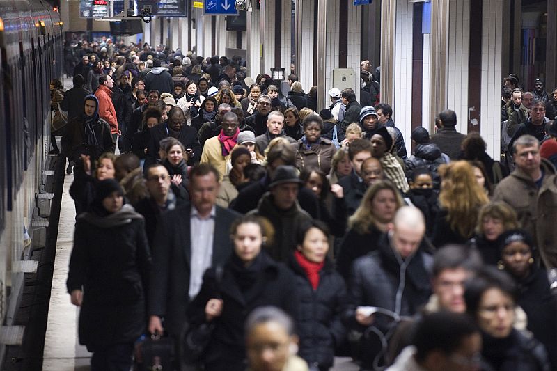 Commuters walk on a platform as they arrive at Gare du Nord train station in Paris