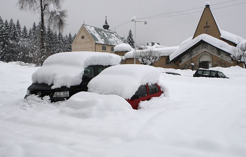 Coches cubiertos totalmente por la nieve en la ciudad de Cortina d'Ampezzo, al norte de Italia