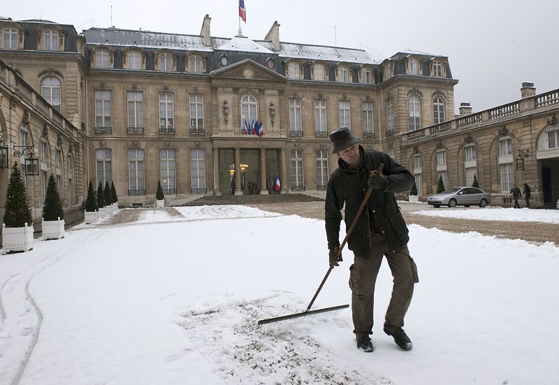 Un trabajador retira la nieve caida en el Palacio del Elíseo en París