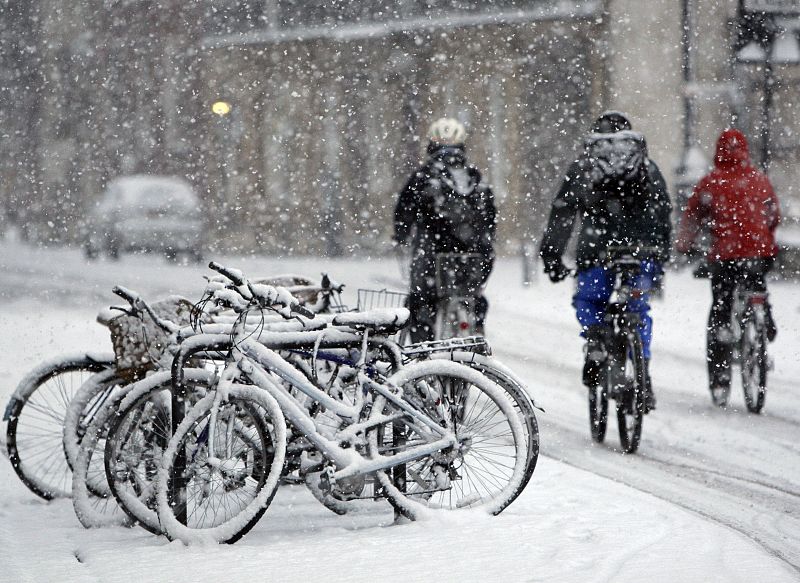 Ciclistas corriendo bajo la nieve en Cambridge, al este de Londres