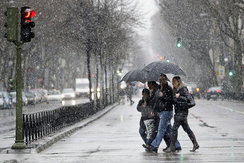 Ciudadanos caminando bajo la nieve en el Paseo de la Castellana en Madrid