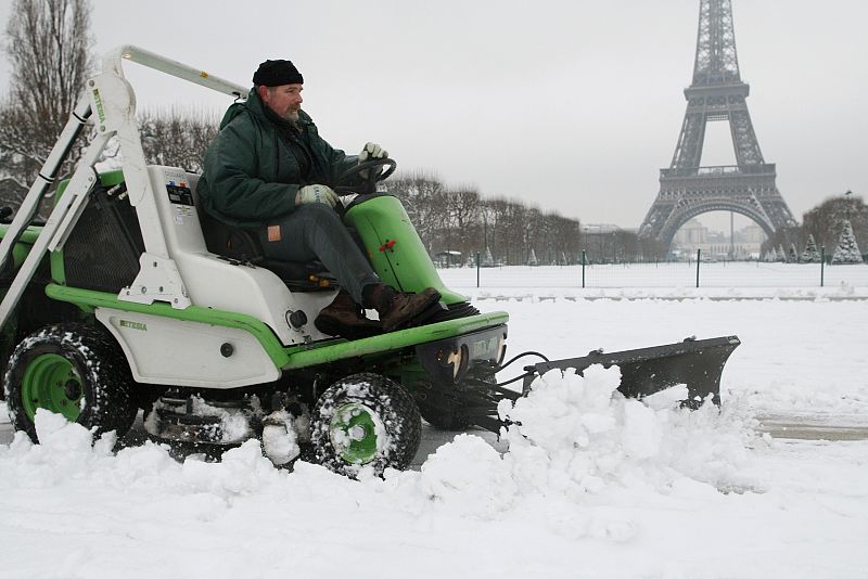 Un máquina quitanieves retira la nieve caida anoche en frente de la Torre Eiffel en París