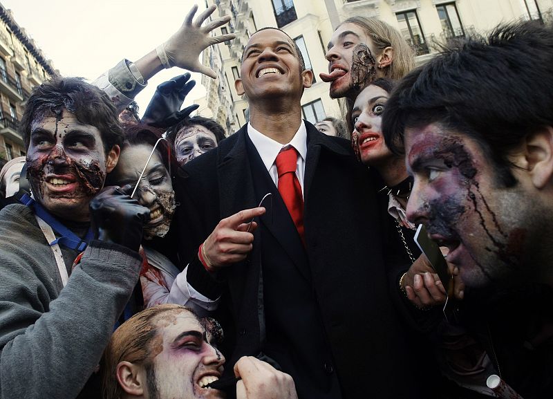 People dressed as zombies surround a U.S. President Barack Obama lookalike during a zombie gathering in Madrid