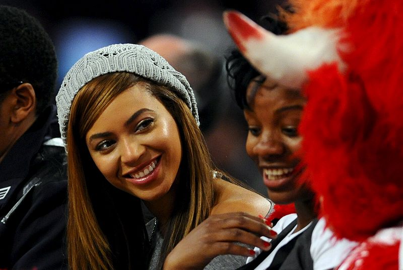 La cantante estadounidense Beyonce bromea con una amiga durante el partido del "All Star".