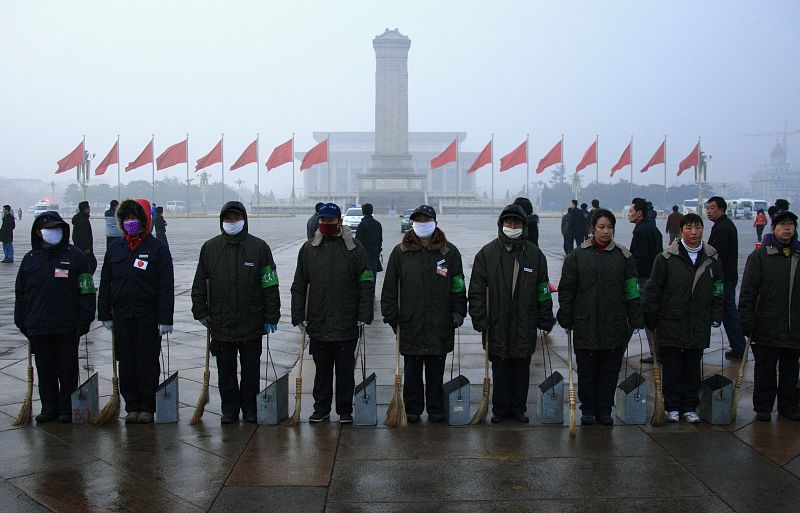 Los trabajadores de limpieza hacen una fila en la plaza de Tiananmen