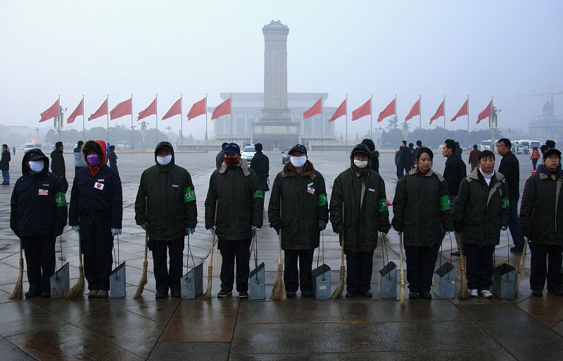 Los trabajadores de limpieza hacen una fila en la plaza de Tiananmen