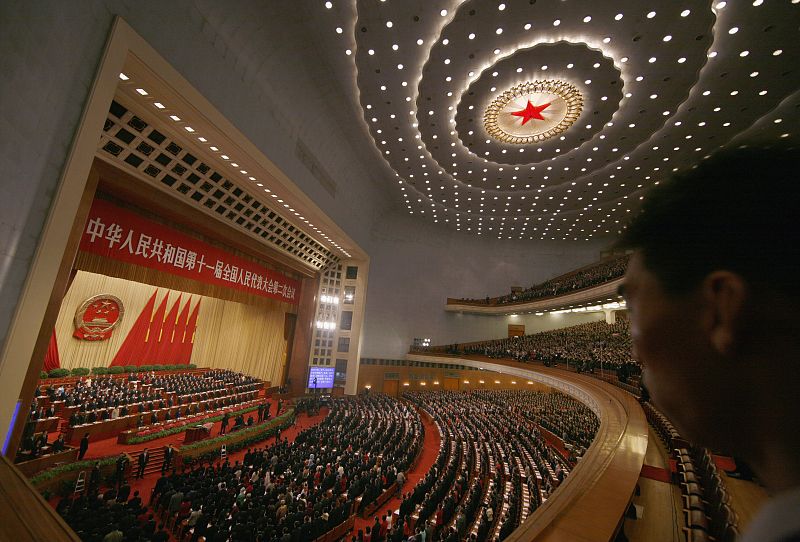 Un guardia de seguridad vigila a los delegados chinos durante el himno nacional