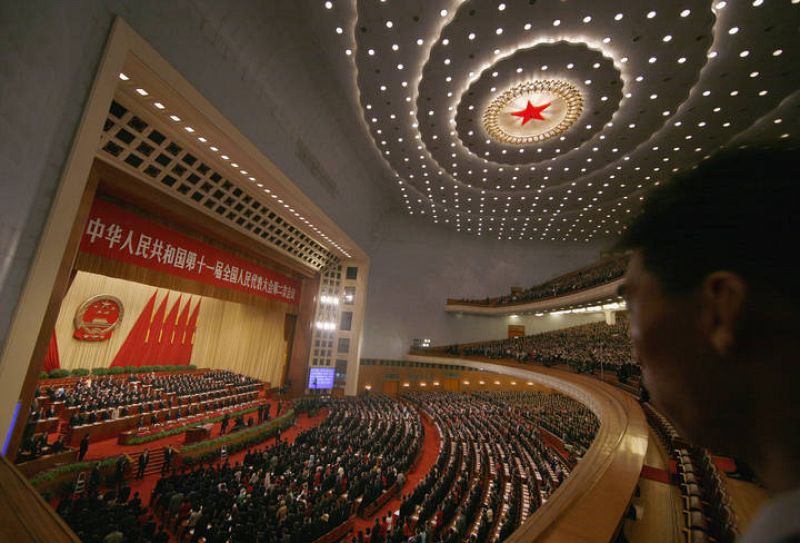 Un guardia de seguridad vigila a los delegados chinos durante el himno nacional 
