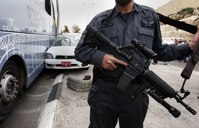 Policía israelí junto a autobús y coche policial