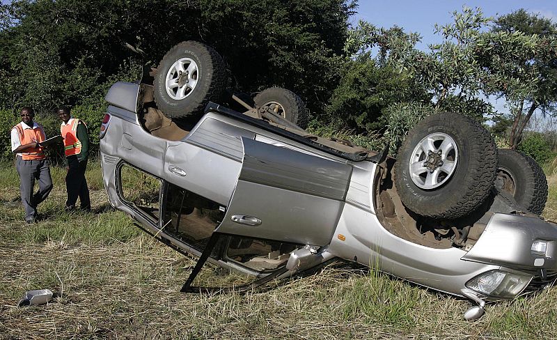 Agentes de la policía de tráfico custodian el coche accidentado