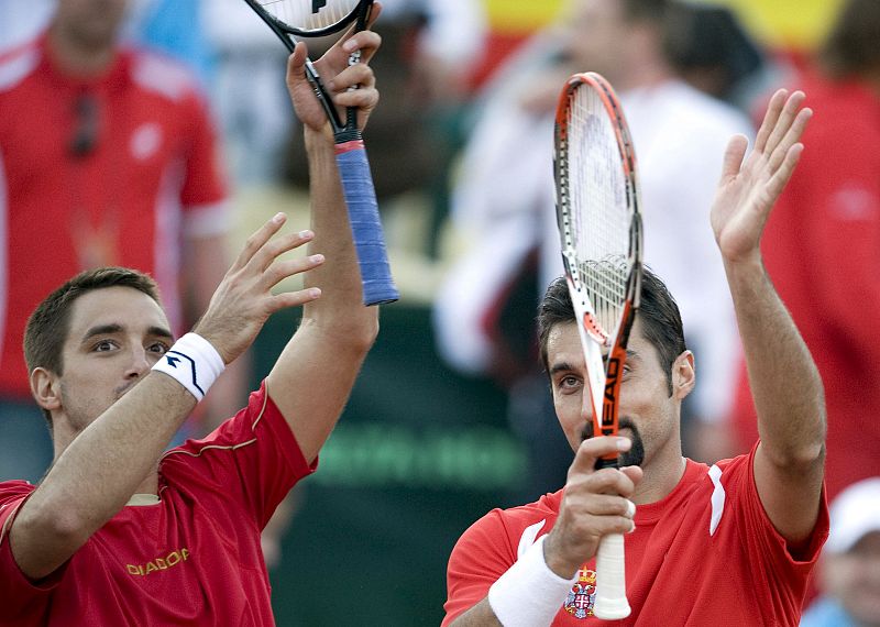 Los tenistas serbios Nenad Zimonjic y Victor Troicki saludan al público tras vencer a Feliciano López y Tommy Robredo en el partido de dobles.