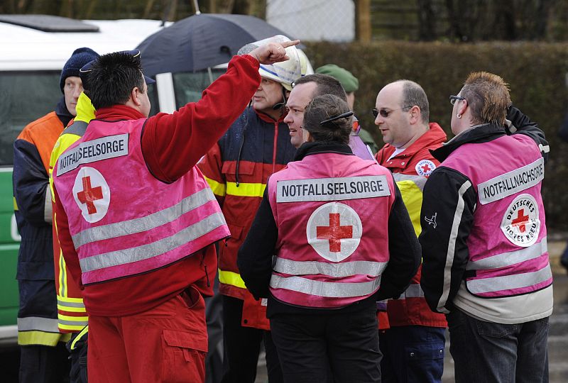 Emergency chaplains gather outside a school where a shooting incident took place in Winnenden