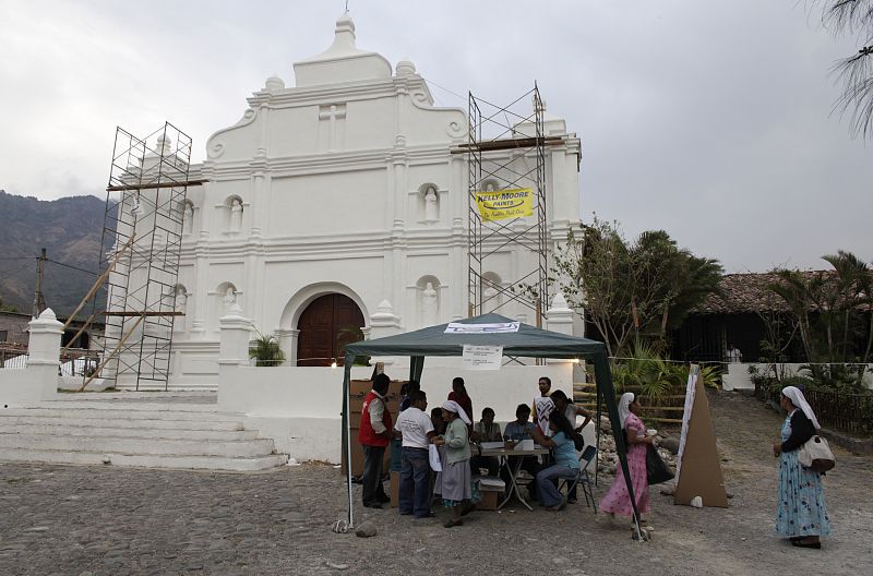 Salvadoreños votan su nuevo presidente en una mesa electoral frente a la principal iglesia de Panchimalco.