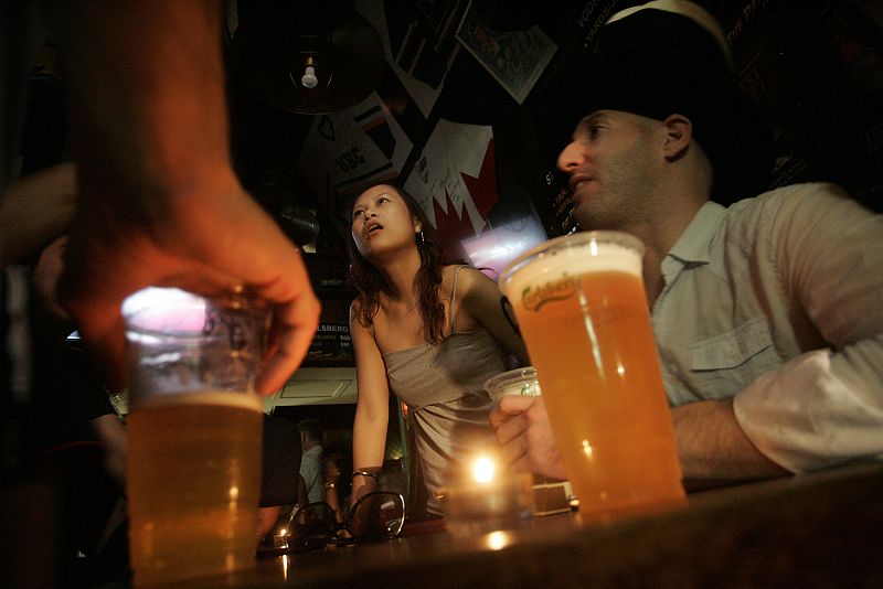 Customers talk under candlelight after lights are switched off at a pub in Lan Kwai Fong during Earth Hour in Hong Kong