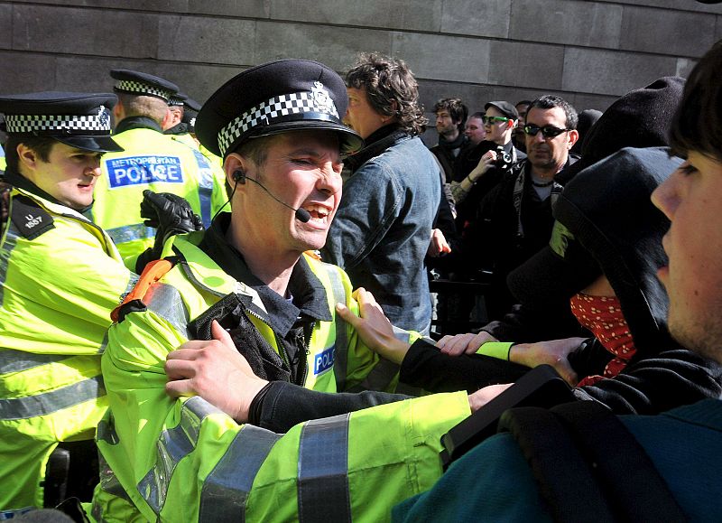 Un policía forcejea con un grupo de activistas anticapitalistas y contrarios al cambio climático durante una manifestación cerca del Banco de Inglaterra