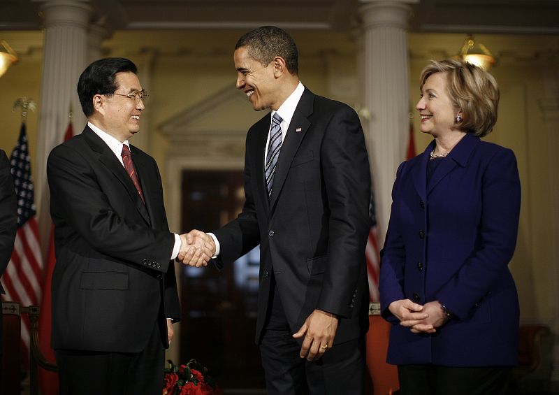 Obama estrecha la mano a Hu Jintao ante la mirada de la secretaria de Estado de EE.UU., Hilarry Clinton.