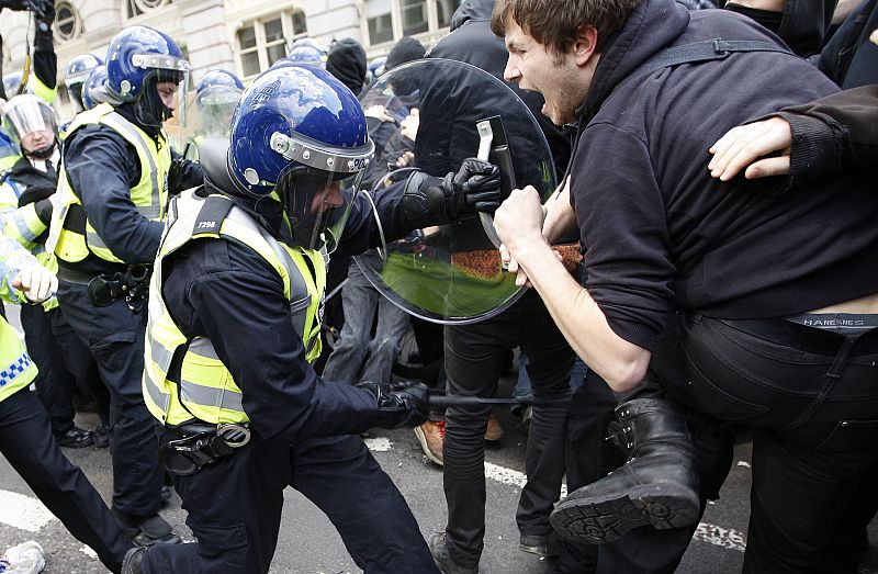La policía golpea con sus porras a los manifestantes cerca del Banco de Inglaterra en Londres.