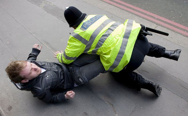 Un policía derriba a un manifestante que protestaba en el exterior de una sucursal del Banco de Inglaterra.