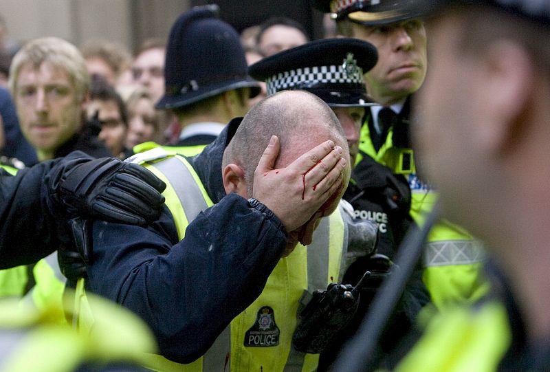 Un agente de policía herido durante los enfrentamientos con los manifestantes en Londres.