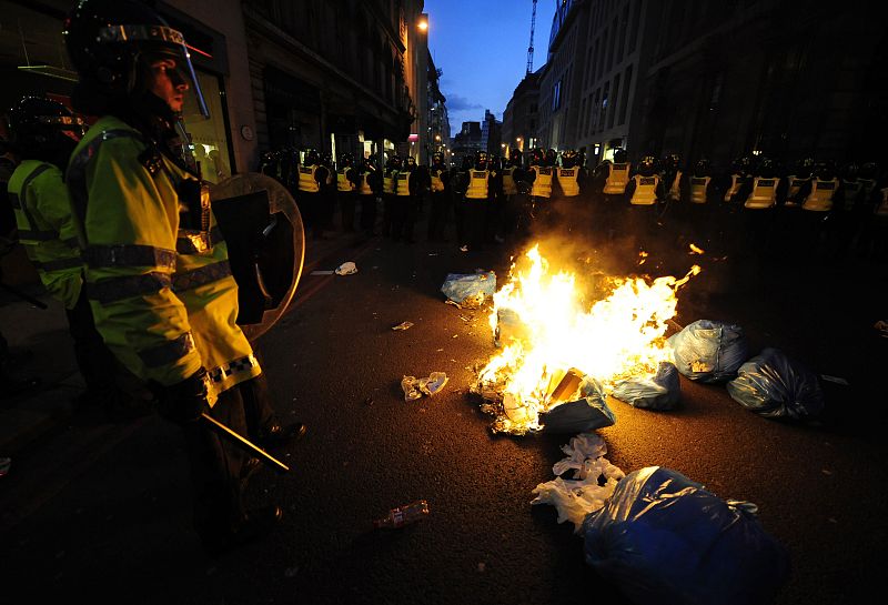 La policía protege el fuego ocasionado por algunos manifestantes.