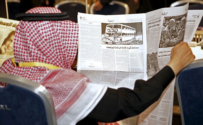 Un delegado de la comitiva de Arabia Saudí lee el periodico en la sala de prensa de la cumbre del G20.