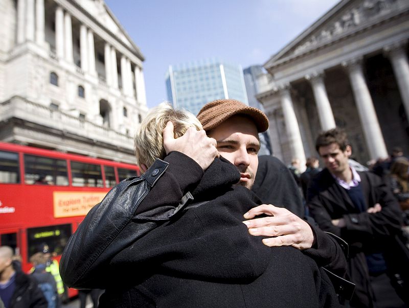 UN HOMBRE CONSUELA A UNA MUJER DURANTE UNA MANIFESTACIÓN FRENTE AL BANCO DE INGLATERRA