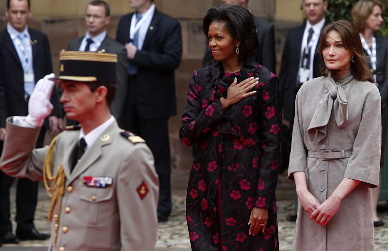 Michelle Obama y Carla Bruni escuchan el himno de EE.UU. durante la ceremonia de bienvenida