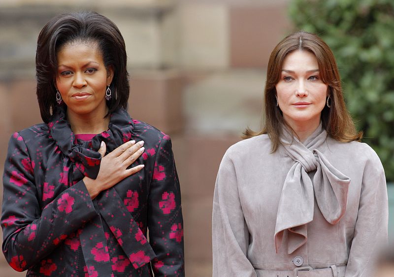 US first lady Obama and France's first lady Bruni-Sarkozy listen to national anthems in Strasbourg