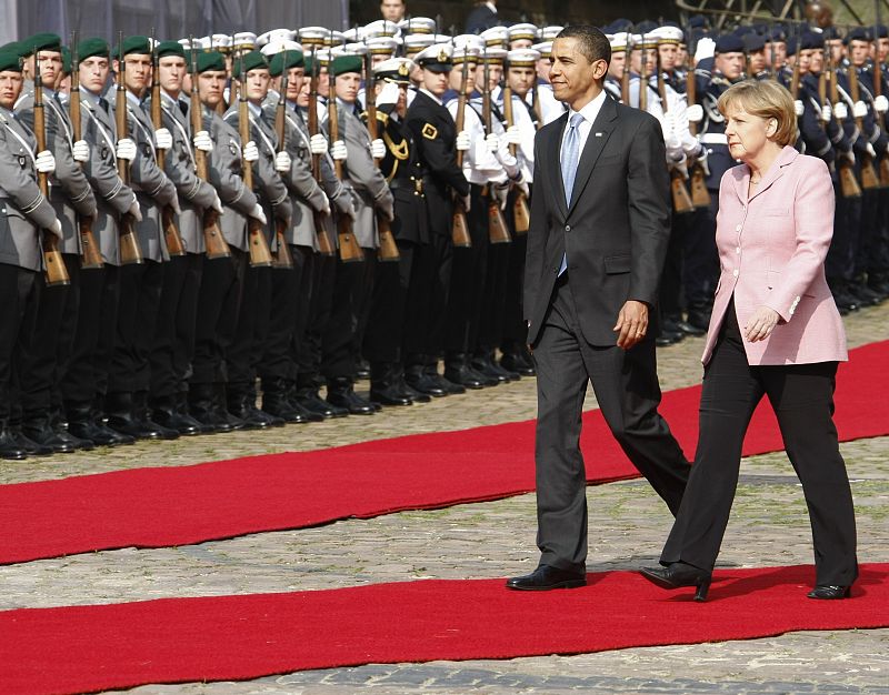 U.S. President Obama and German Chancellor Merkel inspect the guard of honour during a welcoming ceremony at a market place near the town hall in Baden-Baden