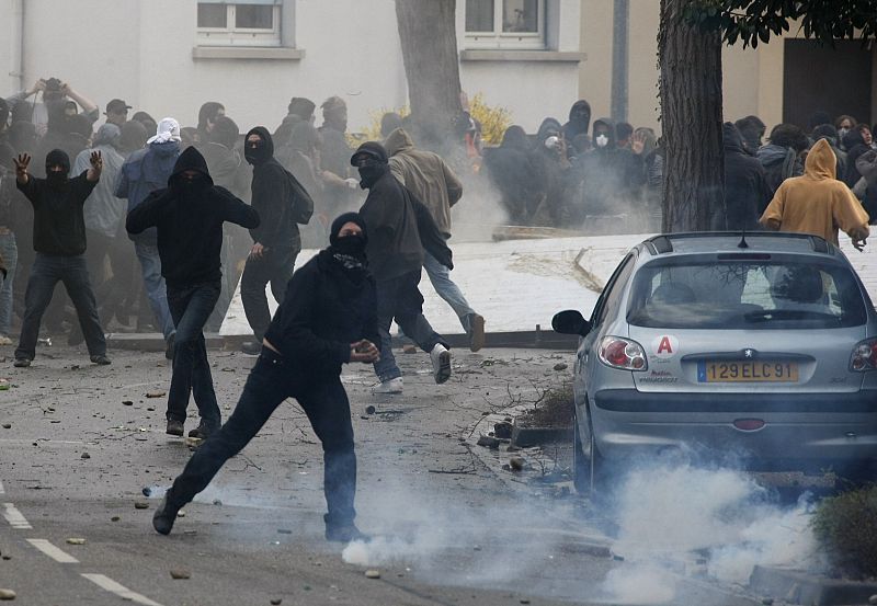 Hooded anti-NATO demonstrators clash with French riot police in the southern suburbs of Strasbourg
