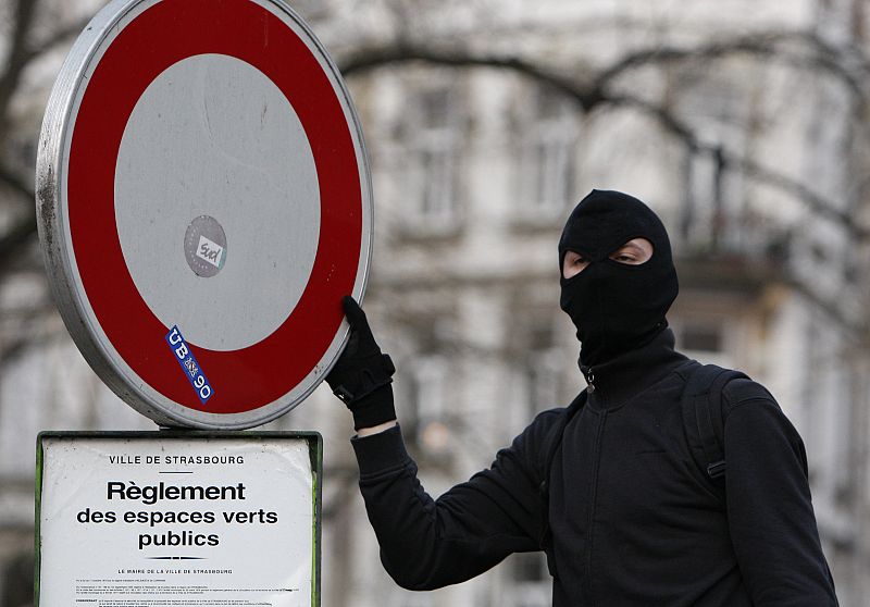 A hooded anti-NATO demonstrator is pictured during protest next to congress center in Strasbourg