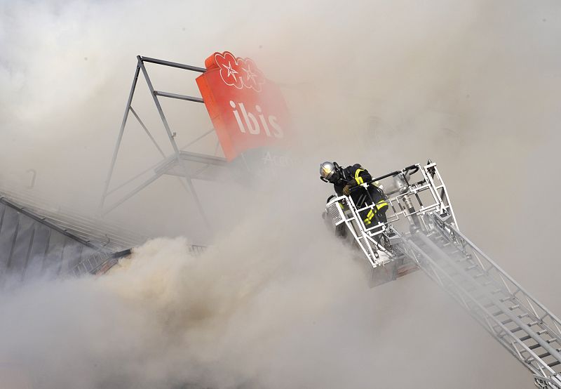 Firefighters try to extinguish the fire of a burning hotel set alight by anti-NATO protesters in Strasbourg