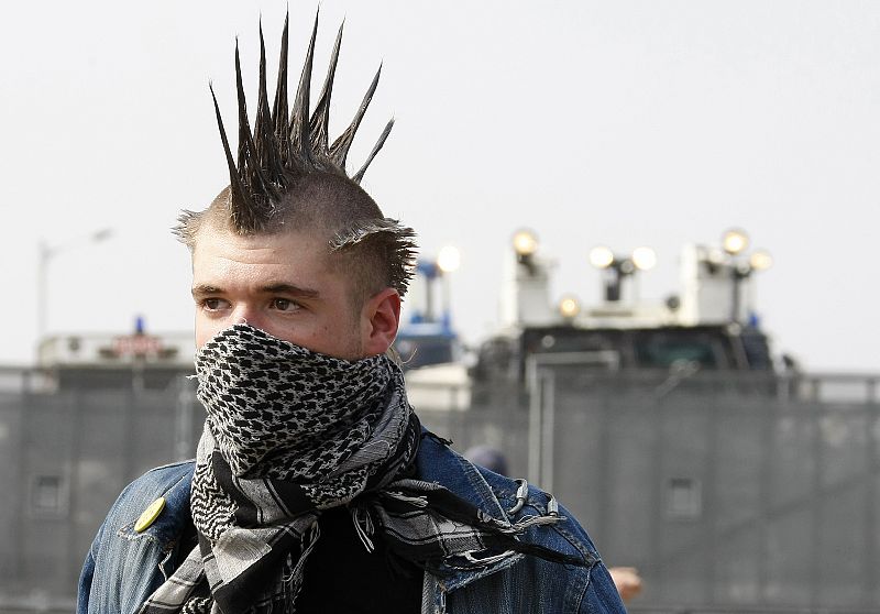 A protester faces riot police with water cannons during an anti-NATO demonstration at the harbour in Strasbourg