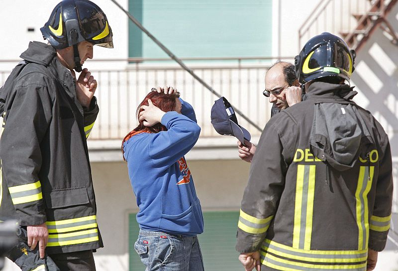 Miembros de los servicios de rescate conversan con una joven que ha resultado herida leve en el terremoto